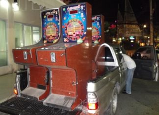 Police load up the confiscated slot machines to truck them away.